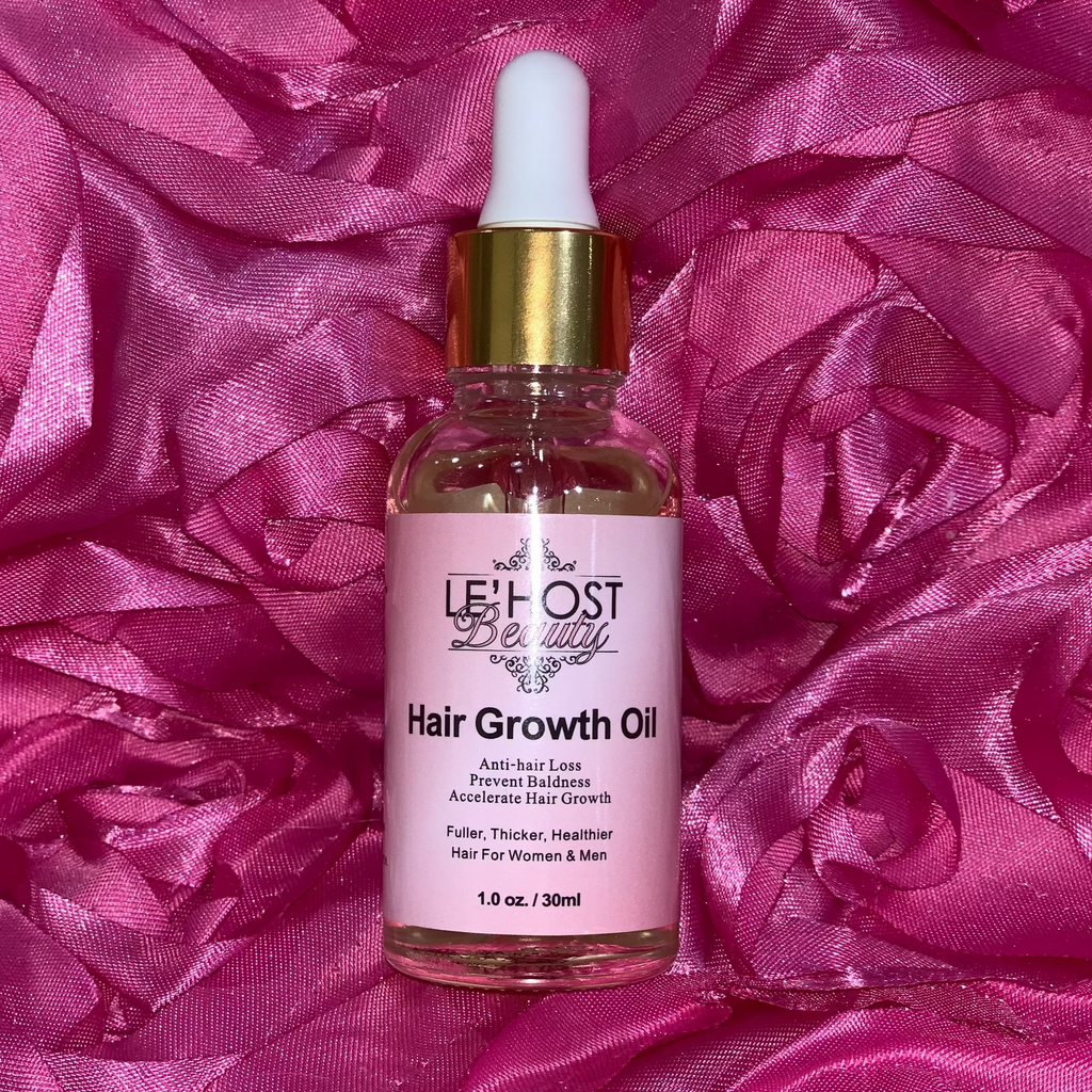 Hair growth oil bottle with dropper on a pink textured background